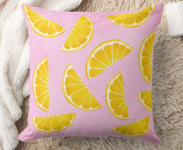 Pillow with orange juice slices on pink background